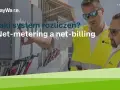 Dwóch mężczyzn w kamizelkach odblaskowych przy panelach, dyskutujących o systemach rozliczeń: net-metering a net-billing.