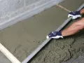 Równanie świeżego betonu na styropianie. Uważaj na wady styrobetonu, jak nierówności czy pęknięcia.