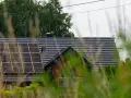 Dach domu z panelami fotowoltaicznymi, które wyglądają na instalację fotowoltaiczną bez zgłoszenia.
