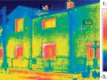 Termowizja domu uwidacznia straty ciepła. Jasne plamy na oknach i dachu wskazują na ucieczkę energii.