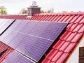 Panele fotowoltaiczne na czerwonym dachu, gotowe do mycia. Czysta energia dla domu.