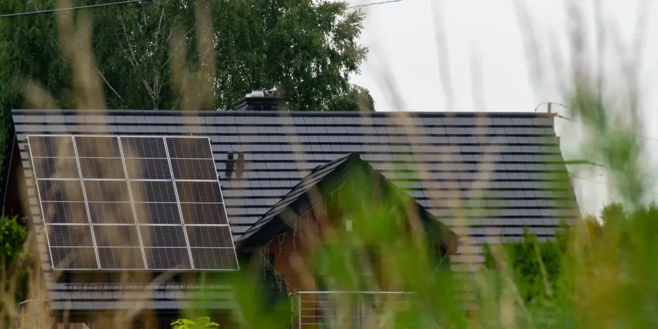 Dach domu z panelami fotowoltaicznymi, które wyglądają na instalację fotowoltaiczną bez zgłoszenia.