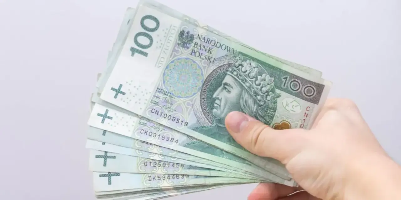 Dłoń trzyma stos banknotów 100 zł. Czy to zapowiedź bonu energetycznego dla każdego?