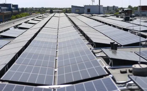 Duże połacie paneli fotowoltaicznych na dachu budynku. To przyszłość energetyki, nawet w bloku!