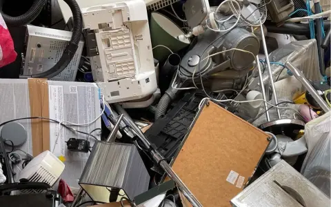 Stary sprzęt AGD, w tym odkurzacz i drukarka, tworzą stos. Zastanawiasz się, gdzie wyrzucić żelazko? To miejsce to idealny przykład elektrośmieci.