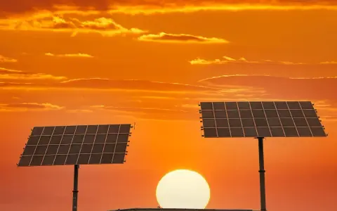 Dwa panele fotowoltaiczne na tle zachodzącego słońca. To pokazuje, co daje fotowoltaika – czystą energię ze słońca.