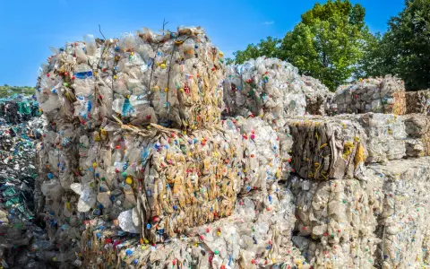 Ogromne bele sprasowanych plastikowych butelek tworzą krajobraz wysypiska śmieci. Kolorowe nakrętki dodają im niepokojącego uroku.