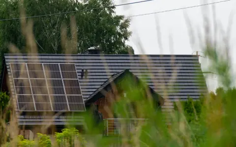 Dach domu z panelami fotowoltaicznymi, które wyglądają na instalację fotowoltaiczną bez zgłoszenia.