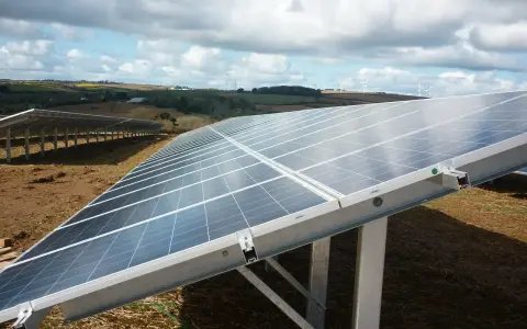 Panele słoneczne na farmie wiatrowej. Optymalizator Tigo zapewnia wydajność systemu, maksymalizując produkcję energii.
