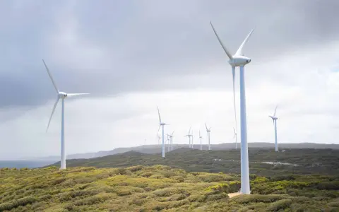 Wiatraki na wzgórzu, symbolizujące zalety elektrowni wiatrowej i czystą energię.