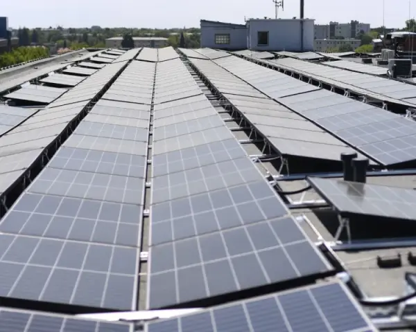 Duże połacie paneli fotowoltaicznych na dachu budynku. To przyszłość energetyki, nawet w bloku!