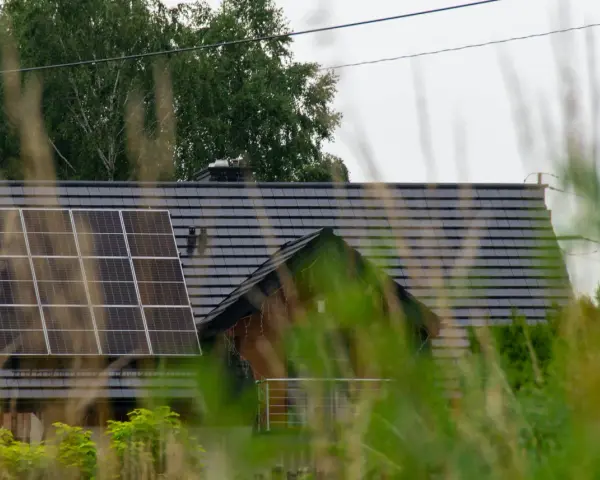 Dach domu z panelami fotowoltaicznymi, które wyglądają na instalację fotowoltaiczną bez zgłoszenia.