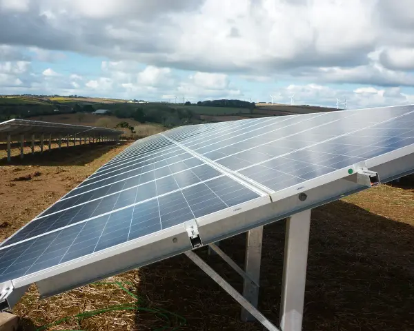 Panele słoneczne na farmie wiatrowej. Optymalizator Tigo zapewnia wydajność systemu, maksymalizując produkcję energii.