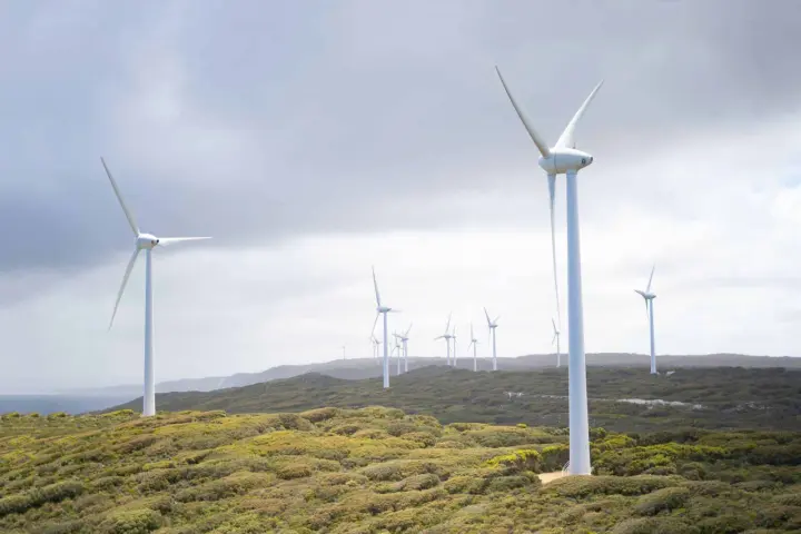 Wiatraki na wzgórzu, symbolizujące zalety elektrowni wiatrowej i czystą energię.
