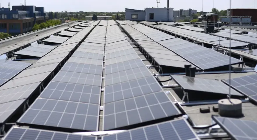 Duże połacie paneli fotowoltaicznych na dachu budynku. To przyszłość energetyki, nawet w bloku!
