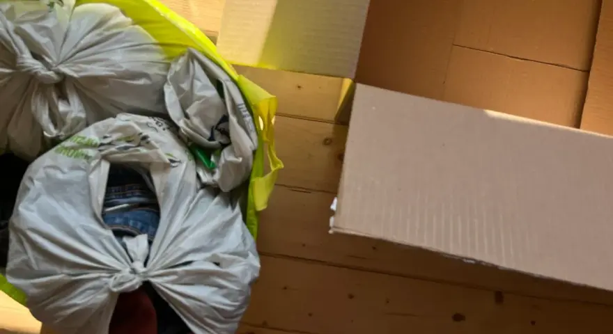 Worek z rzeczami do oddania leży obok otwartego kartonu.