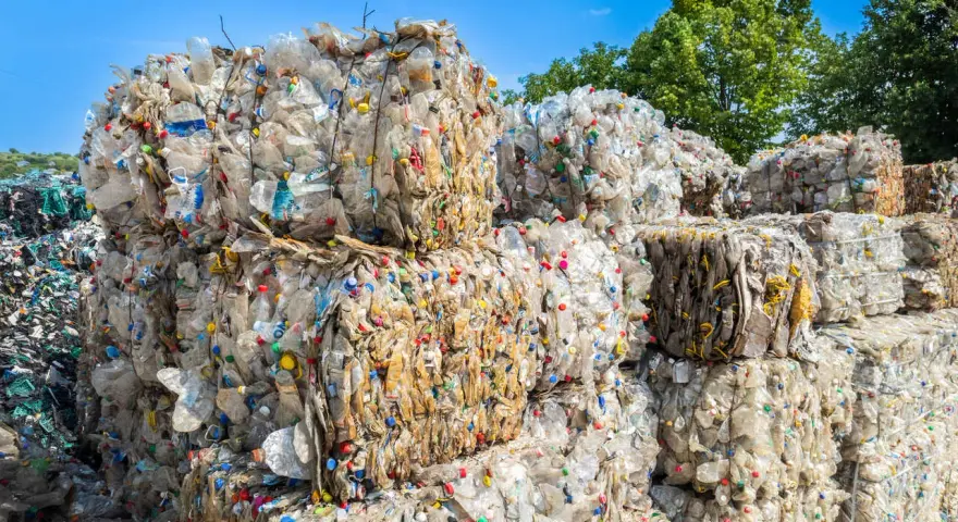 Ogromne bele sprasowanych plastikowych butelek tworzą krajobraz wysypiska śmieci. Kolorowe nakrętki dodają im niepokojącego uroku.