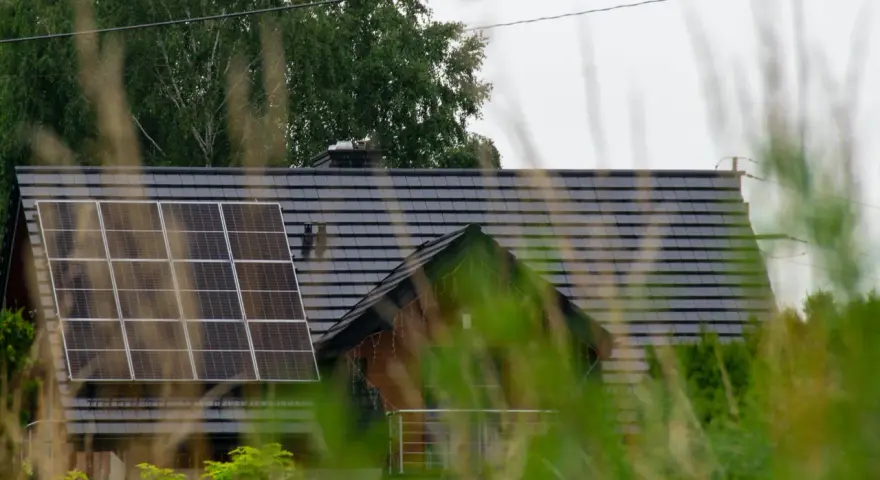 Dach domu z panelami fotowoltaicznymi, które wyglądają na instalację fotowoltaiczną bez zgłoszenia.