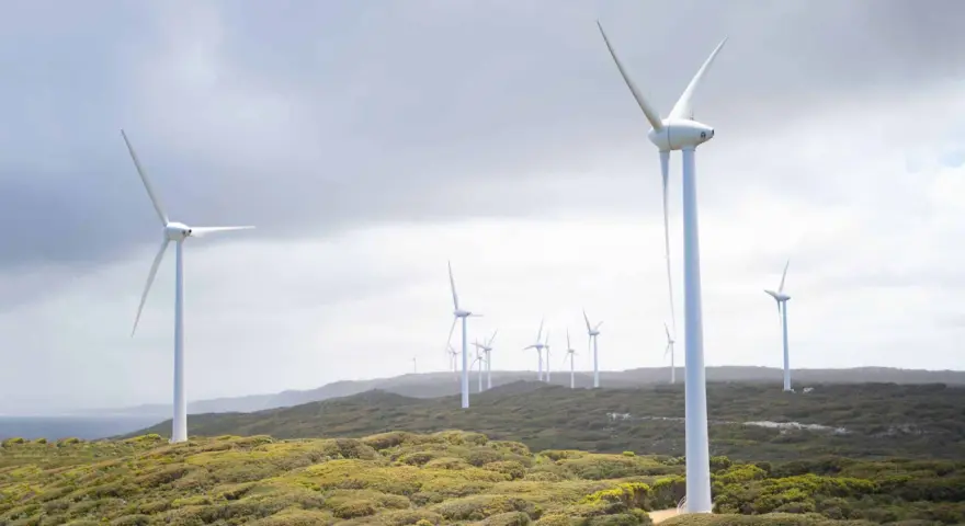Wiatraki na wzgórzu, symbolizujące zalety elektrowni wiatrowej i czystą energię.