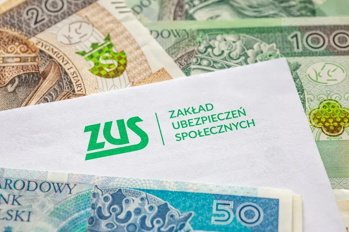 Koperta ZUS na tle polskich banknotów. Emeryt może otrzymać ryczałt energetyczny.